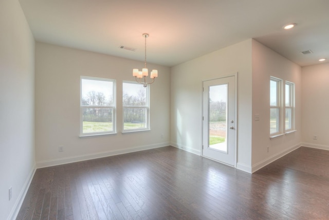 spare room with a chandelier, recessed lighting, dark wood-style flooring, visible vents, and baseboards