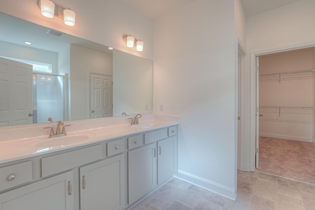 full bath featuring an enclosed shower, a sink, baseboards, and double vanity