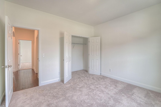 unfurnished bedroom featuring a closet, carpet flooring, and baseboards