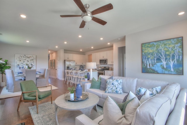 living area featuring a ceiling fan, recessed lighting, and dark wood-style flooring