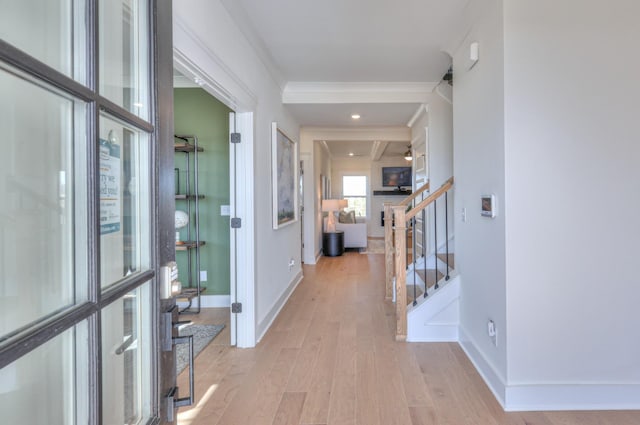 foyer featuring light wood-type flooring, baseboards, stairway, and crown molding