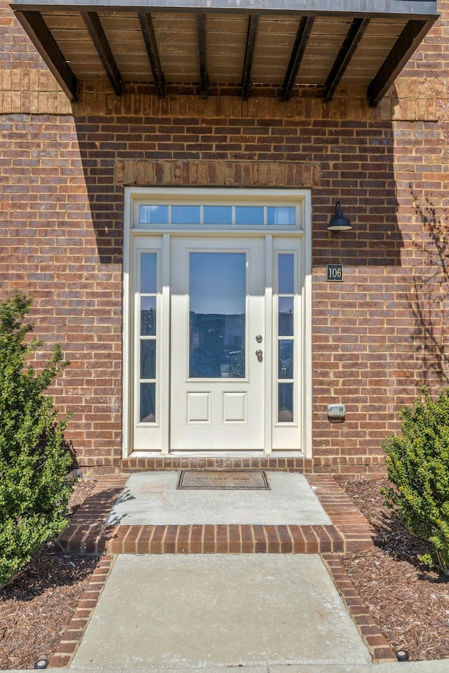 property entrance featuring brick siding