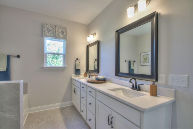 full bathroom featuring double vanity, baseboards, a sink, and a bath