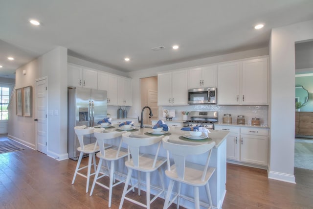 kitchen featuring light countertops, appliances with stainless steel finishes, dark wood finished floors, and white cabinets