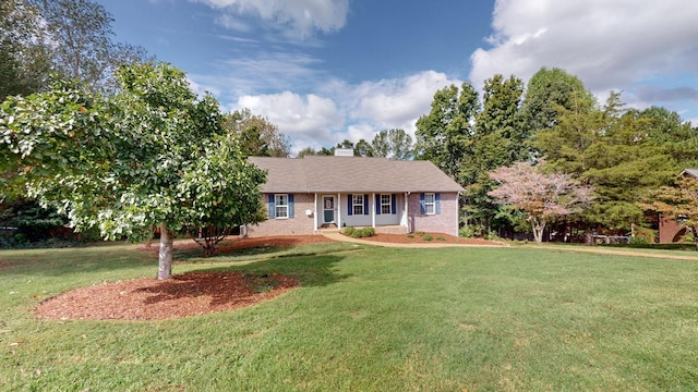 single story home with brick siding, a chimney, and a front lawn