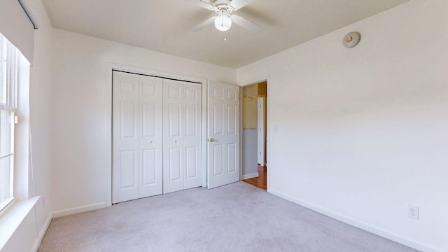 unfurnished bedroom with a closet, baseboards, ceiling fan, and carpet flooring