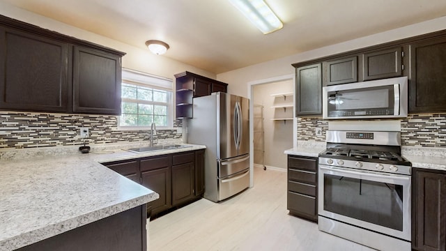 kitchen with light countertops, dark brown cabinets, appliances with stainless steel finishes, and a sink