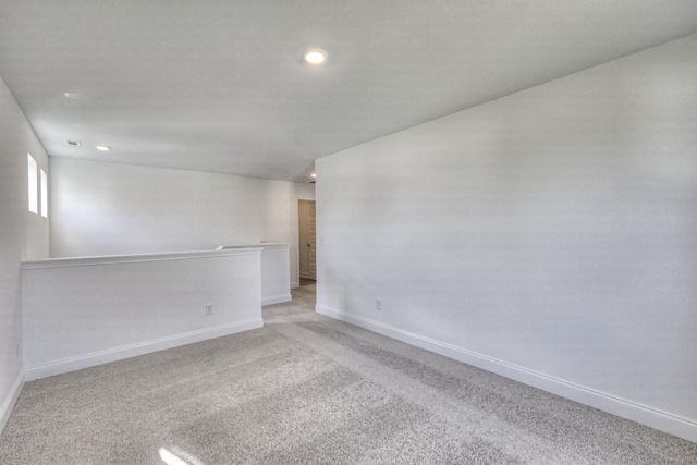 unfurnished room featuring recessed lighting, light colored carpet, and baseboards