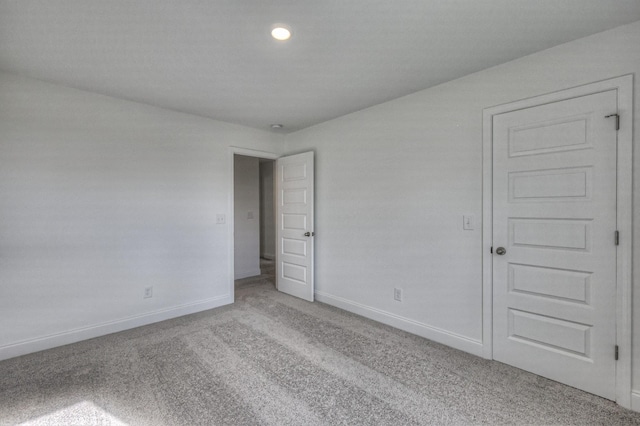 spare room featuring carpet floors and baseboards