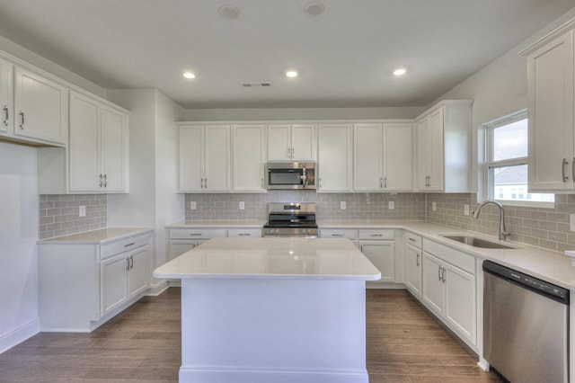 kitchen with a sink, visible vents, white cabinetry, appliances with stainless steel finishes, and dark wood finished floors