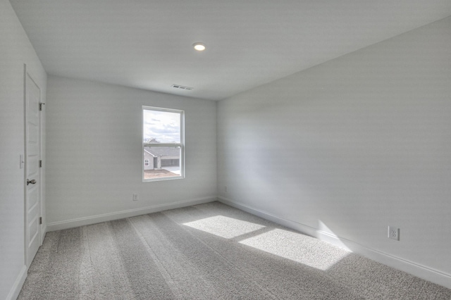 carpeted empty room with visible vents and baseboards