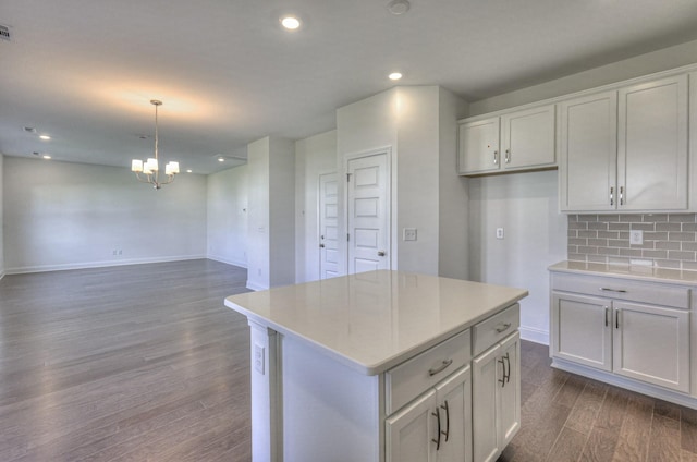 kitchen featuring a kitchen island, backsplash, dark wood-type flooring, and light countertops