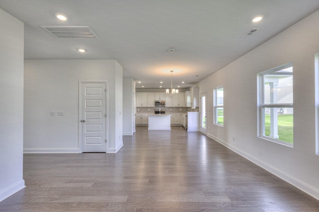 unfurnished living room featuring recessed lighting, visible vents, dark wood finished floors, and baseboards