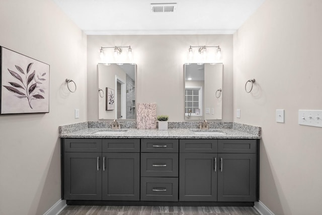 full bathroom featuring double vanity, baseboards, visible vents, and a sink