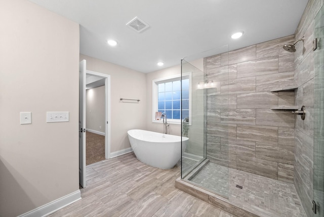 bathroom featuring visible vents, baseboards, recessed lighting, a stall shower, and a soaking tub