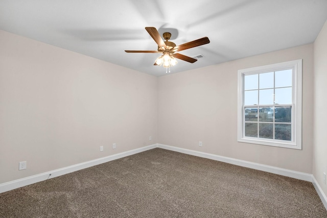 empty room with visible vents, a ceiling fan, baseboards, and dark carpet