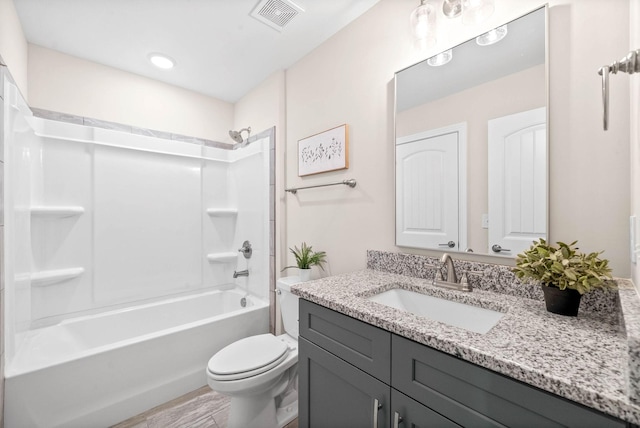 bathroom featuring vanity, toilet, visible vents, and shower / washtub combination