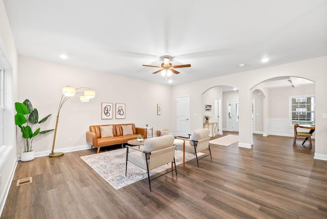 living area featuring wood finished floors, visible vents, baseboards, recessed lighting, and arched walkways