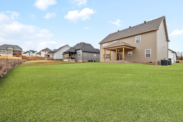 back of house with crawl space, central air condition unit, a residential view, and a yard