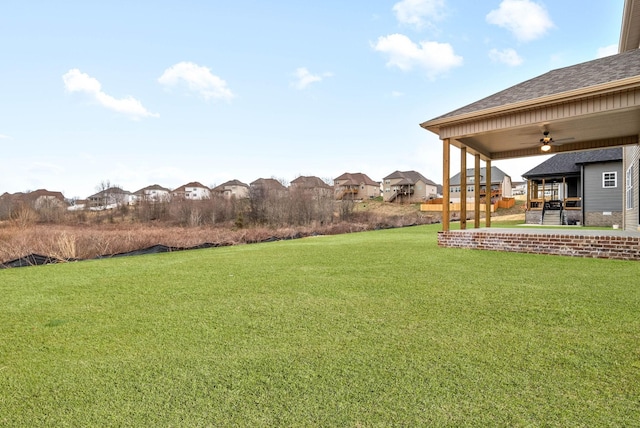 view of yard featuring a residential view, a patio, and ceiling fan