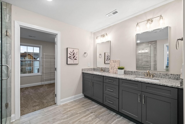 full bath with double vanity, visible vents, a stall shower, and a sink