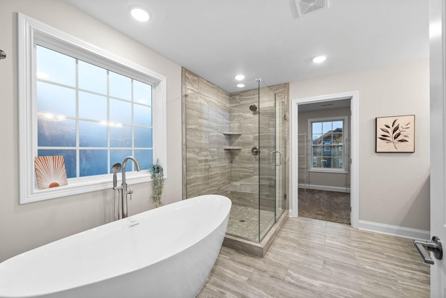 full bathroom featuring visible vents, baseboards, a freestanding bath, recessed lighting, and a stall shower