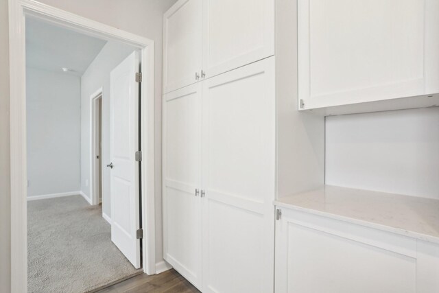 hallway featuring baseboards and wood finished floors