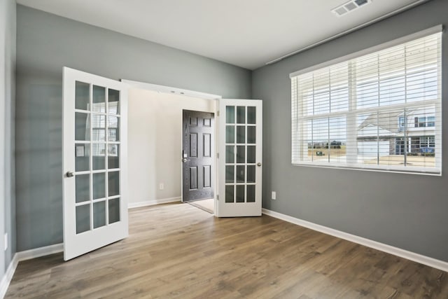 spare room with visible vents, wood finished floors, and french doors