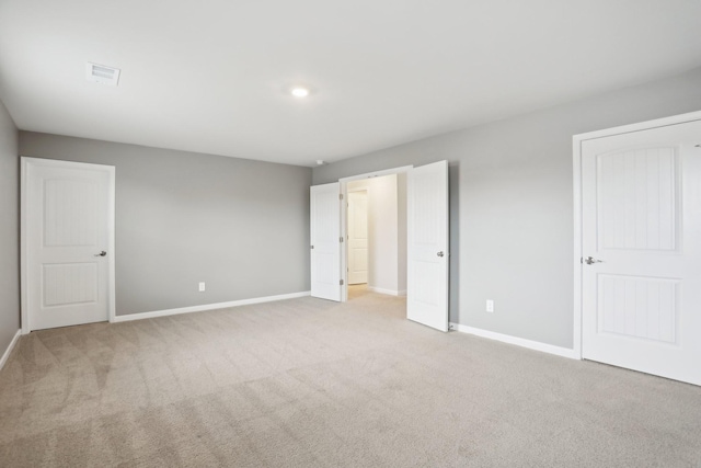 unfurnished bedroom featuring carpet floors, visible vents, and baseboards