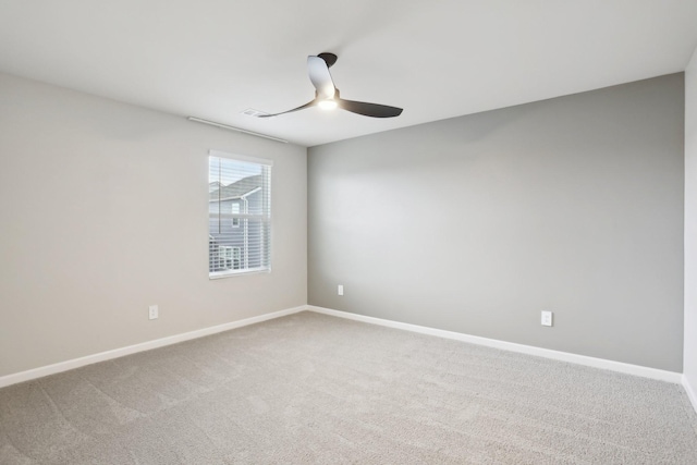 empty room with ceiling fan, baseboards, and light colored carpet