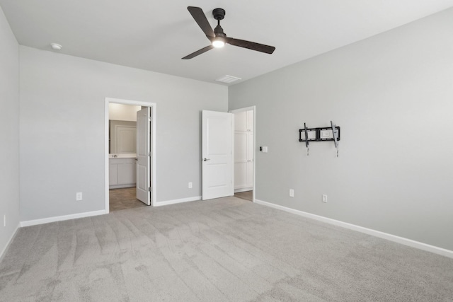 unfurnished bedroom with a ceiling fan, carpet, ensuite bath, and baseboards