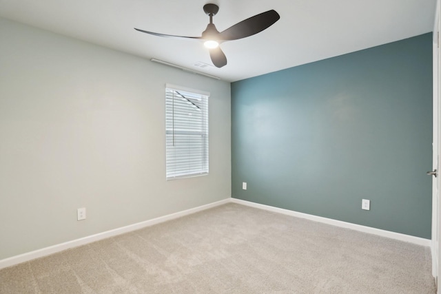 spare room with visible vents, carpet floors, a ceiling fan, and baseboards