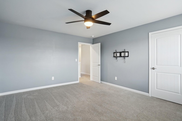 unfurnished bedroom featuring carpet, a ceiling fan, and baseboards