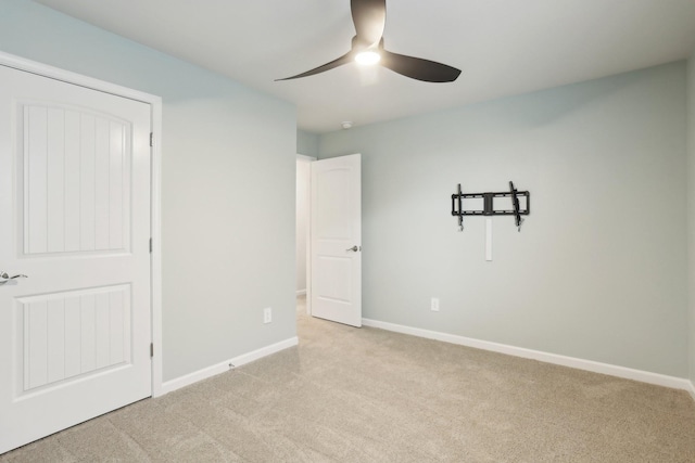 unfurnished bedroom featuring a ceiling fan, light carpet, and baseboards