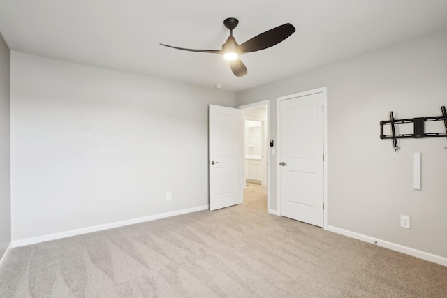 unfurnished bedroom with light carpet, ceiling fan, and baseboards