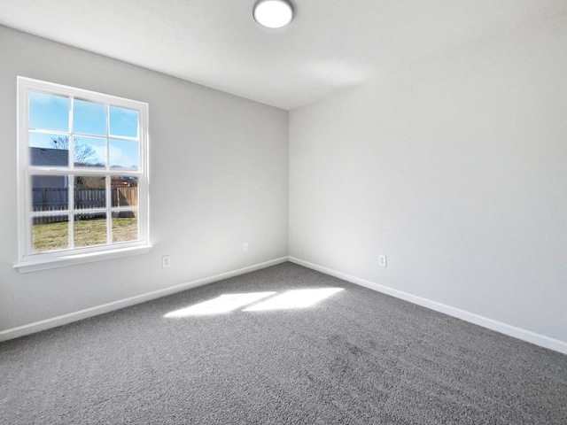 carpeted spare room featuring baseboards