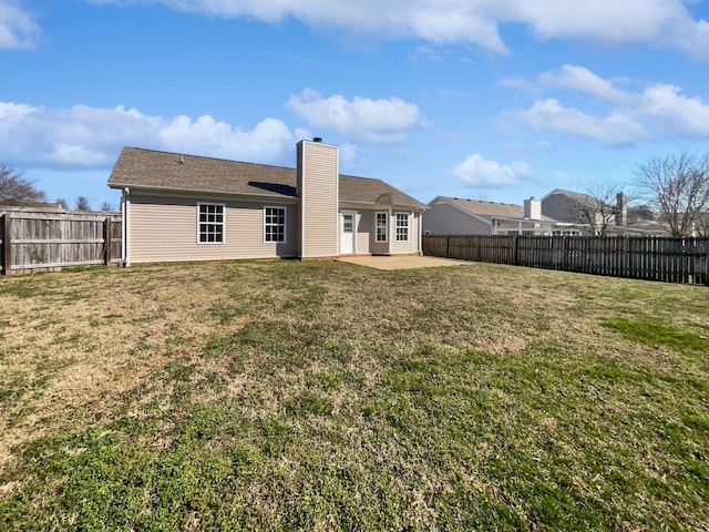 rear view of house with a patio area, a fenced backyard, a chimney, and a yard