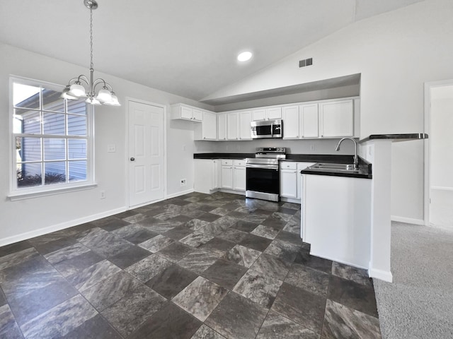 kitchen with stainless steel appliances, dark countertops, white cabinets, a sink, and baseboards