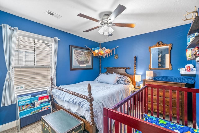 carpeted bedroom featuring baseboards, visible vents, and a ceiling fan