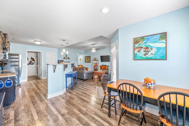 dining space with ceiling fan, wood finished floors, and baseboards