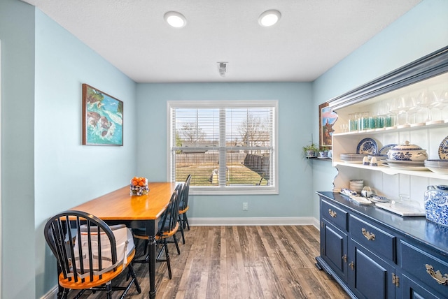 dining space featuring baseboards and wood finished floors