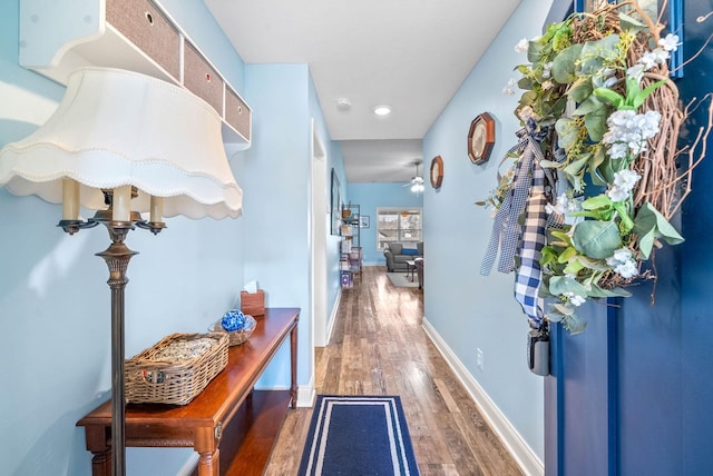 corridor with wood finished floors and baseboards