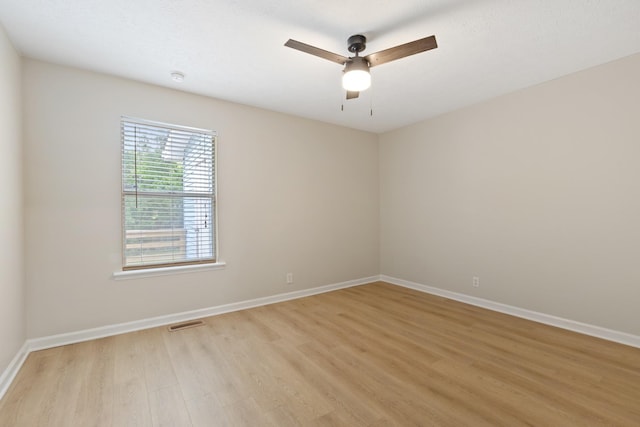 empty room with a ceiling fan, baseboards, visible vents, and light wood finished floors