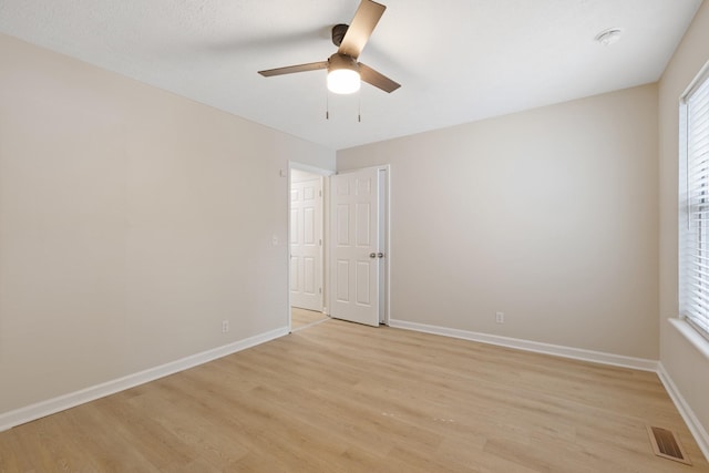 unfurnished room featuring baseboards, visible vents, and light wood-style floors