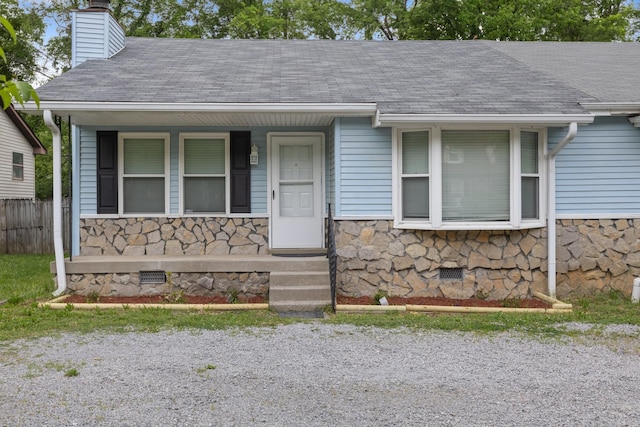 view of front of property featuring stone siding, a chimney, roof with shingles, crawl space, and a porch