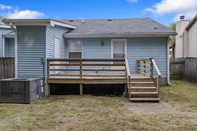 rear view of house featuring a fenced backyard, central AC unit, a deck, and a lawn