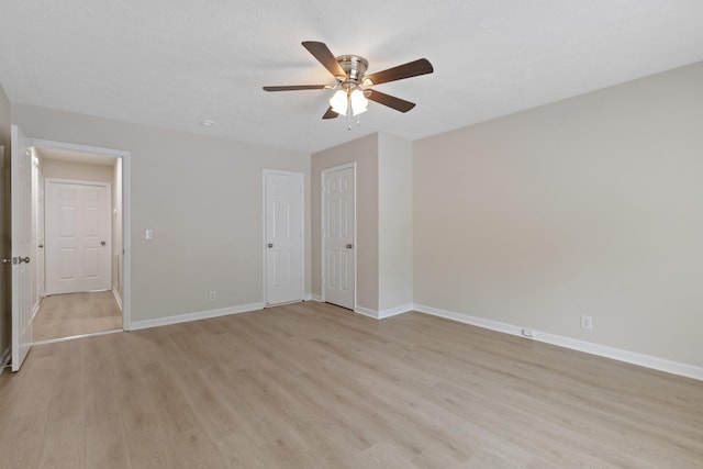 unfurnished bedroom with light wood finished floors, ceiling fan, baseboards, and a textured ceiling