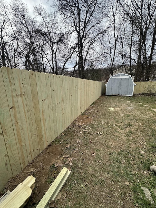 view of yard featuring a fenced backyard, an outdoor structure, and a storage shed