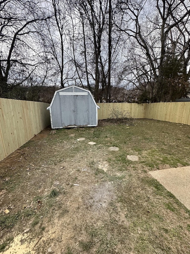 view of yard featuring a storage shed, an outdoor structure, and a fenced backyard