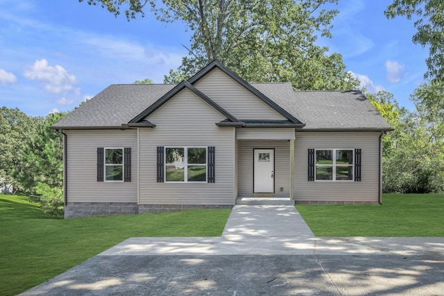 view of front of property with roof with shingles and a front lawn